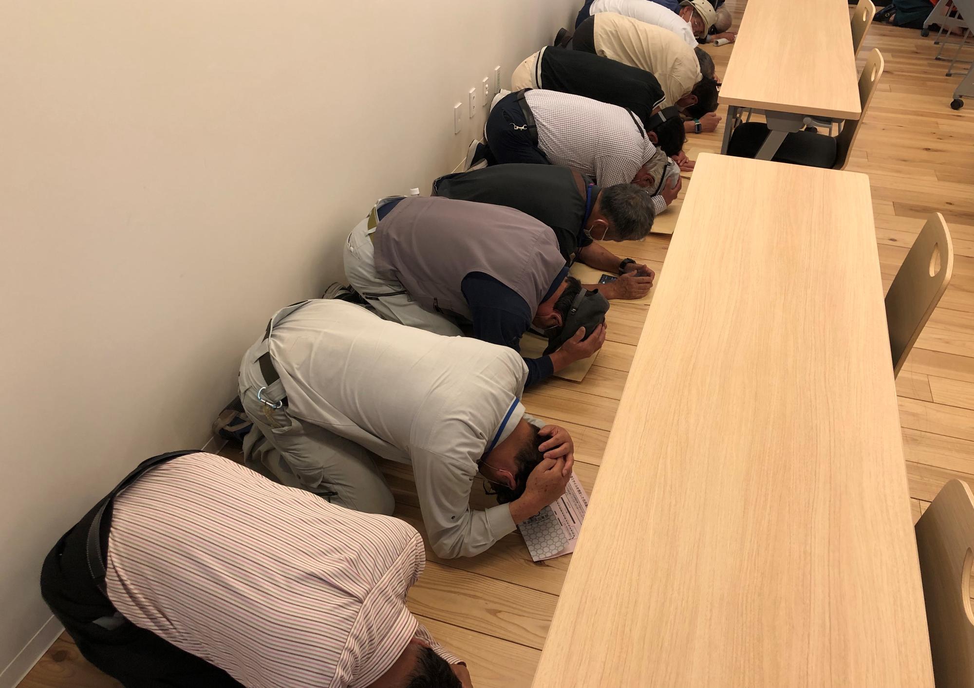 窓の無い場所で頭部を守っている様子の写真