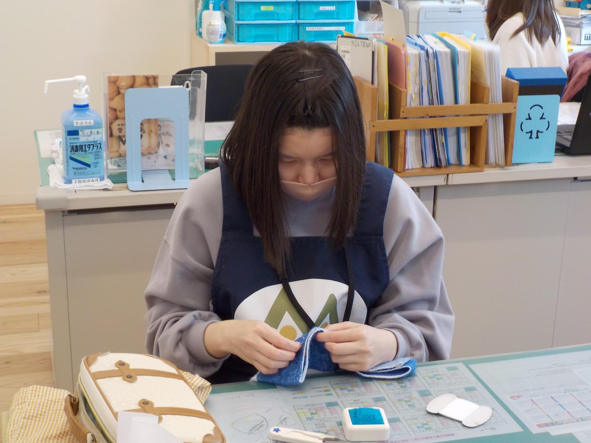 清掃に使う雑巾縫いをする高校生ボランティアの様子